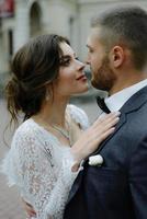 el novio con un traje gris y la novia con un vestido gris se miran, retrato cerrado foto