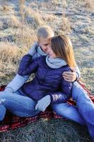 Young pretty fashion sensual couple in love sitting in winter cold field