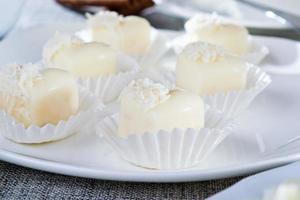 Chocolates in heart shaped white chocolate on the tablecloth photo