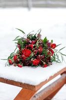 Wedding decorations for the ceremony in the street in the winter. A table, candles, dishes, brightly red colors. photo