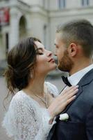 el novio con un traje gris y la novia con un vestido gris se miran, retrato cerrado foto