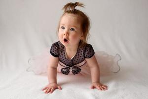 niña de 6 meses con un peine en la mano sobre un fondo blanco. foto