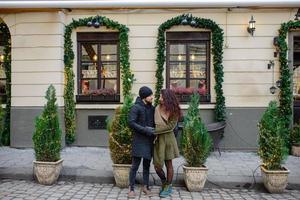 joven pareja romántica se divierte al aire libre en invierno antes de navidad. disfrutando pasar tiempo juntos en la víspera de año nuevo. dos amantes se abrazan y besan en el día de san valentín. foto