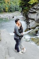 pareja increíblemente hermosa y encantadora en el fondo de un río de montaña foto