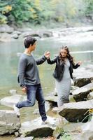 pareja increíblemente hermosa y encantadora en el fondo de un río de montaña foto