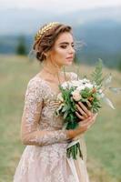 Beautiful bride in fashion wedding dress on natural background.The stunning young bride is incredibly happy. Wedding day. .A beautiful bride portrait in the forest. photo