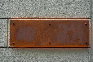 Old rusty metal sign on the wall. photo