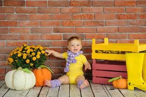 The little one-year-old girl smiles and sits. photo