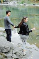 pareja increíblemente hermosa y encantadora en el fondo de un río de montaña foto