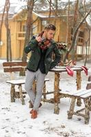 Portrait of a bearded groom in a stylish suit with suspenders and bow-tie in winter at a ski resort photo