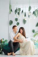 Couple With Pregnant Woman Relaxing On Sofa Together photo