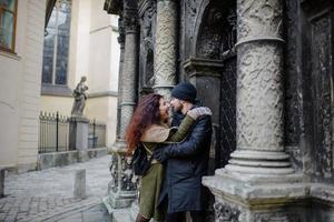 pareja amorosa divirtiéndose al aire libre. hombre cubriendo los ojos de mujer con gorra. foto