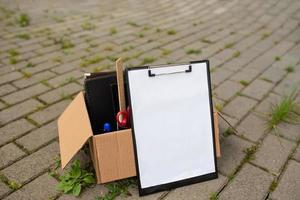 Paper tablet on the background of a box with stationery on cobblestones. photo