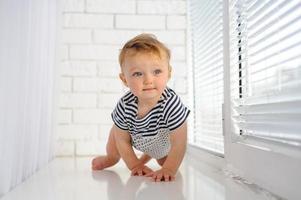 la niña de un año sonríe y se sienta. foto