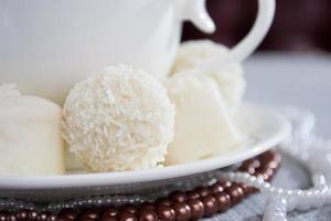 heart-shaped chocolates with candies in coconut flakes of beads photo