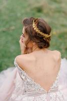 Beautiful bride back view. Bouquet of tulips in the bride's hands photo