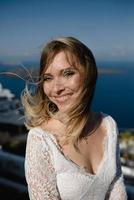 Bride in a wedding dress on the beach by the sea against the background of a blue sky. photo