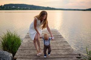 Father and mother lead their one-year-old son by the hand. photo