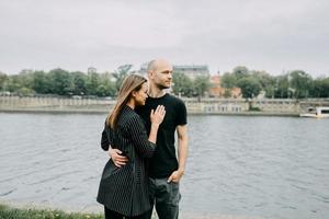 retrato de una feliz pareja romántica con café caminando al aire libre en la vieja ciudad europea foto