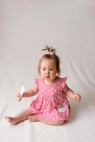 Little girl 6 months old with a comb in hand on a white background. photo