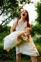 Mom hugs and plays with her one-year-old daughter wrapped in a towel after bathing. photo