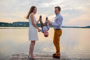 Father and mother lead their one-year-old son by the hand. photo