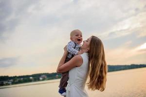 Father and mother lead their one-year-old son by the hand. photo