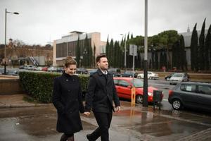 Young beautiful loving Hispanic couple walks under an umbrella during the rain. photo