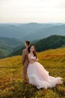 Stylish young bride and groom stand in boat on background cloude sky sea and mountains of Montenegro photo