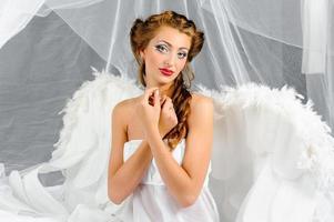 mujer sexy disfrazada de ángel posando frente a la cámara. foto
