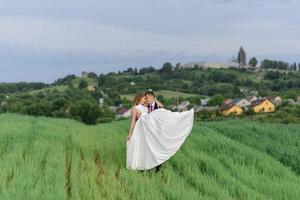 Bride and groom in a wheat field. The couple hugs during sunset photo