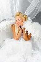 Sexy blonde woman in angel costume posing in front of the camera. photo