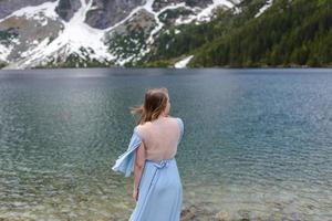 Portrait of a young woman on the background of the Polish lake Sea Eye in the Tatra Mountains. Portrait photography in the background of a quiet place without people. photo