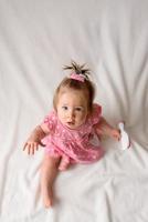 Little girl 6 months old with a comb in hand on a white background. photo