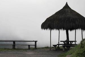 asiento en la cima de la montaña con niebla cubierta, silueta foto