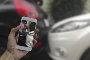 Hand holding smart phone take a photo at The scene of a car crash, car accident.