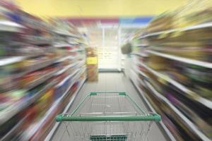 pasillo de supermercado con carrito de compras vacío, tienda de supermercado fondo borroso abstracto con carrito de compras foto