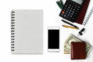White office desk with smartphone with black screen, pen, wallet, and supplies. Top view with copy space photo