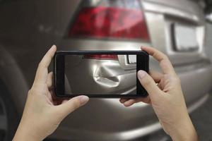 Hand holding smart phone take a photo at The scene of a car crash, car accident for insurance