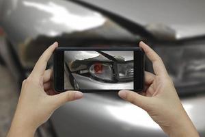 Hand holding smart phone take a photo at The scene of a car crash, car accident for insurance