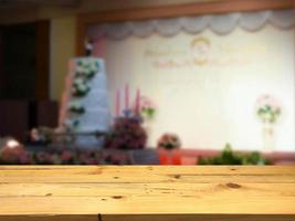 plataforma de espacio de mesa de madera vacía y fondo de salón de bodas borroso para montaje de exhibición de productos foto