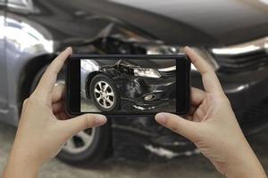 mano sosteniendo un teléfono inteligente, tome una foto en la escena de un accidente automovilístico, accidente automovilístico para el seguro