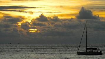 Yacht in the tropical sea at dramatic sunset