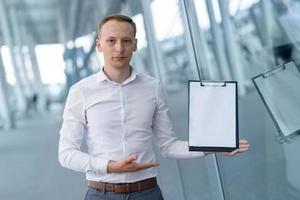 Young businessman shows your text on a tablet. photo