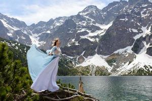 Portrait of a young woman on the background of the Polish lake Sea Eye in the Tatra Mountains. Portrait photography in the background of a quiet place without people.