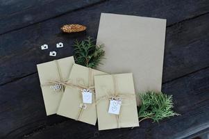 Brown kraft envelopes tied with an old tourniquet on old wood background with copy space. Handmade gift wrap. photo