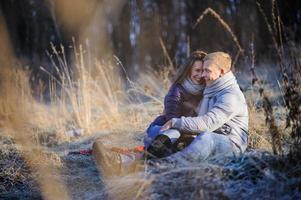 Young pretty fashion sensual couple in love sitting in winter cold field