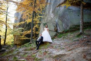 Bride and groom. A couple strolling among the narrow beautiful gorge. The gorge was overgrown with green moss. The newlyweds are spinning and running. photo