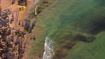 vue aérienne panoramique incroyable de la plage et de l'océan avec des vagues calmes pendant un coucher de soleil aux couleurs vibrantes. Algarve, Portugal. eaux claires. jours fériés et vacances. Contexte. plage avec des rochers. video