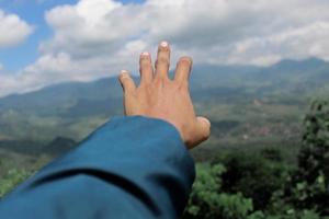 left hand with a beautiful mountain view photo